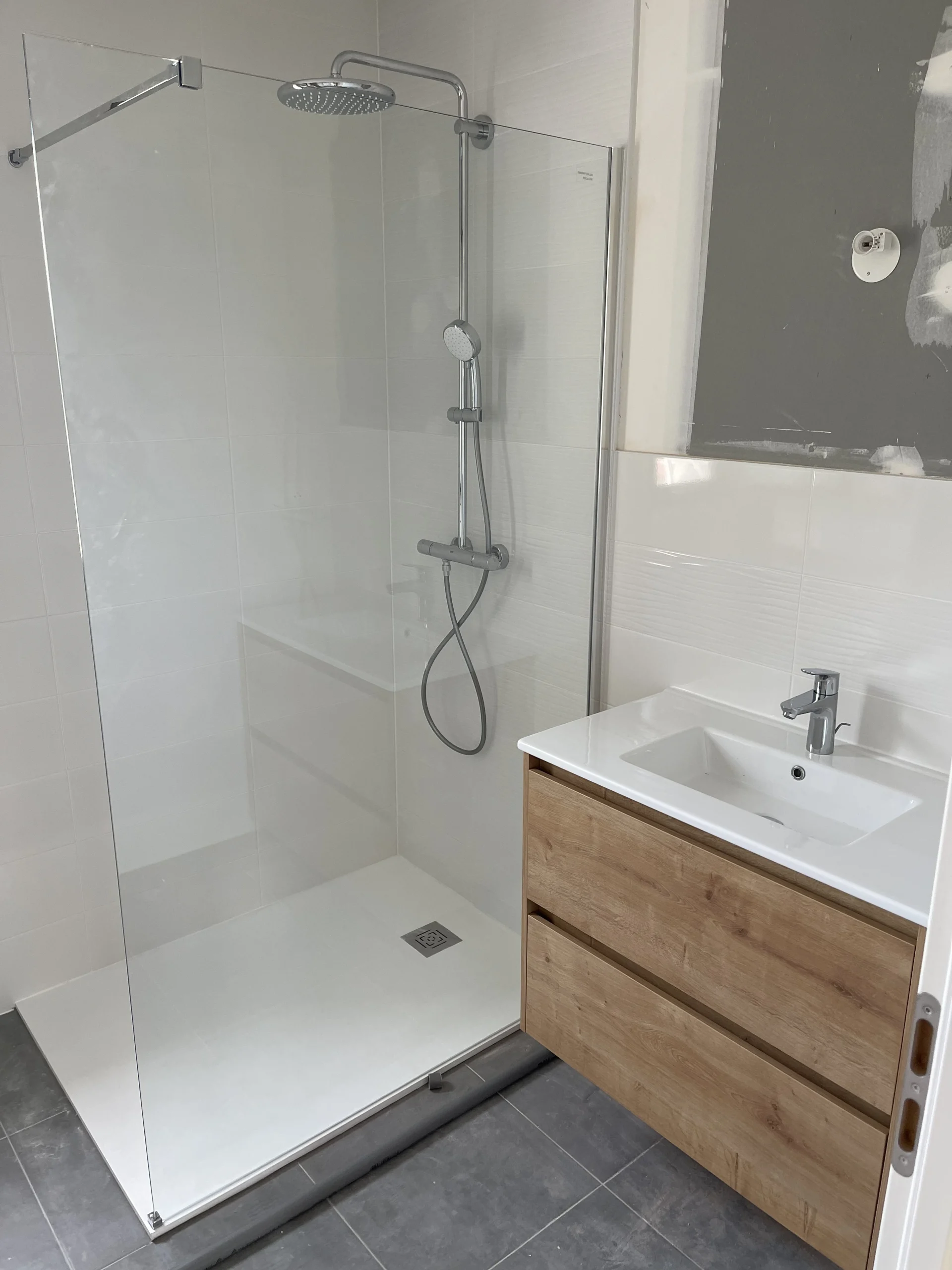 Salle de bain rénovée par Levesque Plomberie avec douche à l'italienne, paroi vitrée et meuble vasque bois